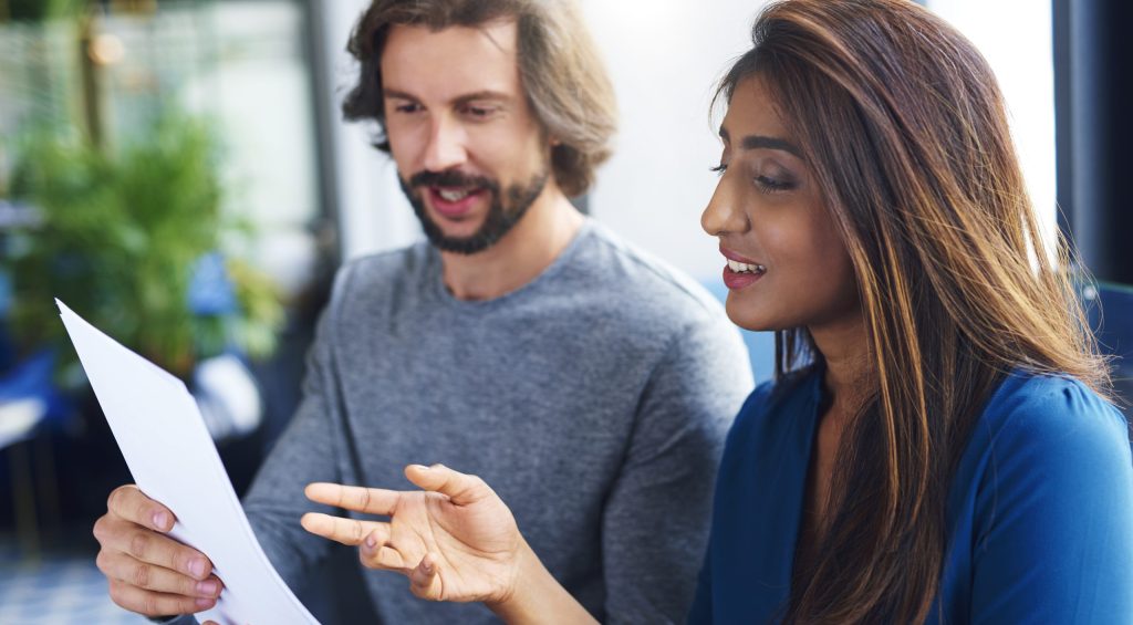 Young adults coworkers analyzing document